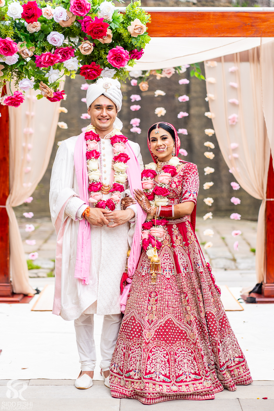 Shubhra and Morgan wearing flower garlands after their Hindu wedding ceremony at Gunners Barracks, Mosman