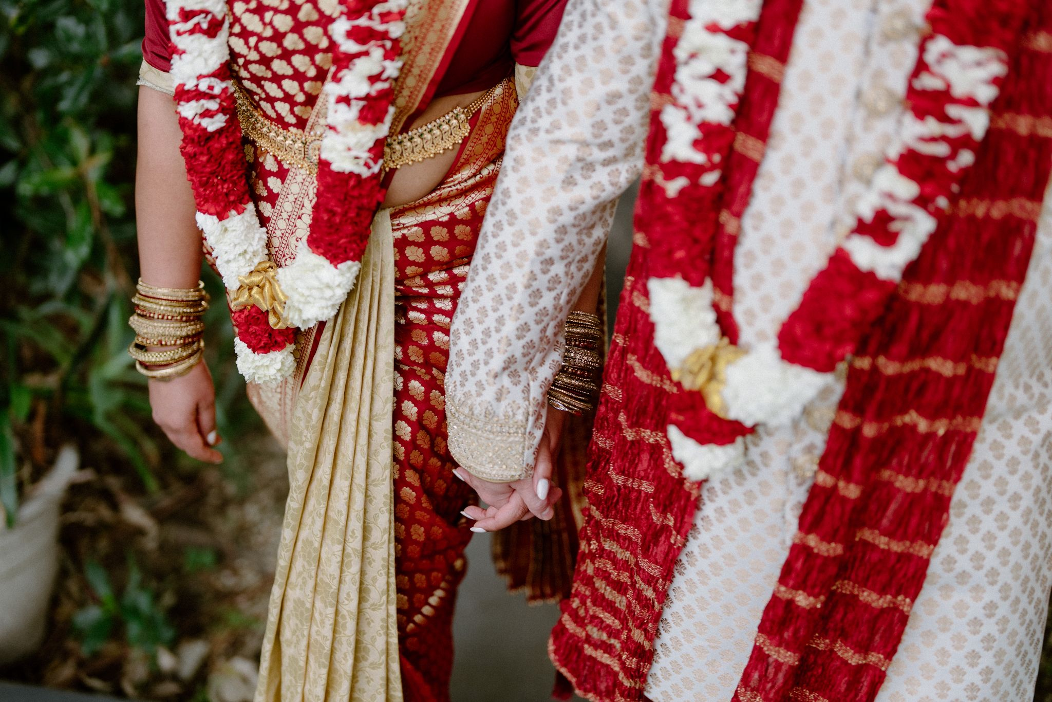 Anushka and Dan in traditional South Indian dress, holding hands during their Hindu wedding ceremony